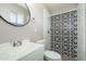 Bathroom featuring designer tile in the shower, and a modern, round mirror at 6223 W Earll Dr, Phoenix, AZ 85033