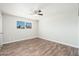 Bright bedroom featuring wood-look floors, a ceiling fan, and a view from the window at 6223 W Earll Dr, Phoenix, AZ 85033