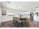 Bright dining area with wood floors flows into an open kitchen featuring white cabinetry and stainless steel appliances at 6223 W Earll Dr, Phoenix, AZ 85033