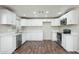 Well-lit kitchen featuring modern white cabinets, stainless steel appliances, and durable countertops at 6223 W Earll Dr, Phoenix, AZ 85033