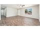 Inviting living room featuring wood-look flooring, a ceiling fan, and a large window for ample natural light at 6223 W Earll Dr, Phoenix, AZ 85033