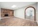 Spacious living room with brick fireplace, wood floors, and a unique archway at 6223 W Earll Dr, Phoenix, AZ 85033