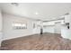 Open-concept kitchen and living room with stainless steel appliances and new vinyl flooring at 6223 W Earll Dr, Phoenix, AZ 85033
