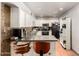 Well-lit kitchen featuring white cabinets, tile backsplash, and bar seating at 6335 W Osborn Rd, Phoenix, AZ 85033