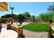 Expansive backyard oasis with lush green lawn, mature trees, and a sparkling pool at 6937 W Jackrabbit Ln, Peoria, AZ 85383