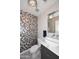 Stylish powder room featuring a unique tiled accent wall and vessel sink at 6937 W Jackrabbit Ln, Peoria, AZ 85383