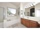 Bright bathroom featuring a large vanity, garden tub, and a large window at 6937 W Jackrabbit Ln, Peoria, AZ 85383