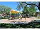 Community playground with shade covering, various play structures, and benches, providing a fun and safe environment for children at 6937 W Jackrabbit Ln, Peoria, AZ 85383