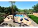 Inviting backyard pool with lounge chairs, manicured lawn, mature landscaping, and clear blue skies at 6937 W Jackrabbit Ln, Peoria, AZ 85383