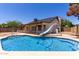 Well-maintained backyard features desert landscaping and a large pool with a slide at 723 E Piute Ave, Phoenix, AZ 85024
