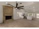 Expansive living room with tile flooring, modern fan, stone fireplace and open to the bright kitchen at 723 E Piute Ave, Phoenix, AZ 85024