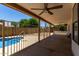 Covered patio with ceiling fan and metal fencing separating patio from the pool area at 723 E Piute Ave, Phoenix, AZ 85024