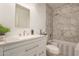 Beautiful bathroom with a marble tiled shower, modern vanity and a large, decorative mirror at 7724 W Oraibi Dr, Glendale, AZ 85308