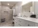 Modern bathroom with marble-tiled shower, sleek vanity, and decorative mirror at 7724 W Oraibi Dr, Glendale, AZ 85308
