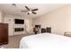 Spacious bedroom featuring fireplace, ceiling fan, and a workstation at 7724 W Oraibi Dr, Glendale, AZ 85308