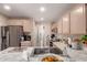 Kitchen island featuring stainless steel sink, light countertops, and stainless steel appliances at 7724 W Oraibi Dr, Glendale, AZ 85308