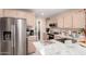 Spacious kitchen features stainless steel refrigerator, light countertops, and painted wood cabinetry at 7724 W Oraibi Dr, Glendale, AZ 85308