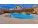 Inviting backyard pool with waterfall feature, blue umbrella, and beautiful desert landscaping at 7724 W Oraibi Dr, Glendale, AZ 85308