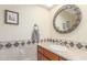 Bathroom vanity with tiled countertop, decorative mirror, and wood cabinets at 8043 E Laurel St, Mesa, AZ 85207