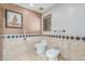 Bathroom featuring toilet, bidet, and decorative tile border at 8043 E Laurel St, Mesa, AZ 85207