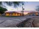 Exterior view of the property featuring desert landscaping, a red tiled roof, and large arched windows at dusk at 8043 E Laurel St, Mesa, AZ 85207