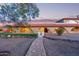 An arched covered walkway with stone paver path leading to a charming single Gathering home at 8043 E Laurel St, Mesa, AZ 85207