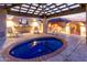 Relaxing backyard hot tub with a covered patio, exterior lighting, and elegant tile and concrete design at 8043 E Laurel St, Mesa, AZ 85207