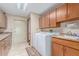 Well-equipped laundry room with wooden cabinets, countertop space, and modern washer and dryer at 8043 E Laurel St, Mesa, AZ 85207