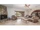 Bright living room featuring a stone fireplace, comfortable seating, and arched windows with views of the outdoors at 8043 E Laurel St, Mesa, AZ 85207