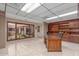 Spacious office featuring tiled floors, built-in shelving, and a large window showcasing an outdoor courtyard at 8043 E Laurel St, Mesa, AZ 85207