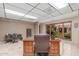 Bright office space with tile flooring, large desk, and windows showcasing an outdoor garden area at 8043 E Laurel St, Mesa, AZ 85207