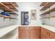 Walk-in pantry featuring custom shelving, ample storage, and a wine cooler at 8043 E Laurel St, Mesa, AZ 85207