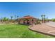 Backyard featuring a lush green lawn and a spacious pavilion with charming arches and a tiled roof at 8043 E Laurel St, Mesa, AZ 85207