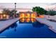 Tranquil backyard pool reflecting the sunset and illuminated patio with beautiful desert landscaping at 8043 E Laurel St, Mesa, AZ 85207