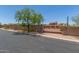 Gated property entrance with stone pillars, a decorative gate, and mature landscaping under a blue sky at 8043 E Laurel St, Mesa, AZ 85207