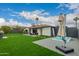 Wide backyard with green grass, a hot tub, grill, and outdoor seating for entertaining at 8252 E Heatherbrae Ave, Scottsdale, AZ 85251