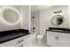 Modern bathroom with dual vanities, sleek black countertops, and updated fixtures at 8252 E Heatherbrae Ave, Scottsdale, AZ 85251
