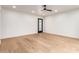 Bright, minimalist bedroom with light wood flooring, ceiling fan, and door with a pane of glass at 8252 E Heatherbrae Ave, Scottsdale, AZ 85251
