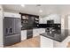 Modern kitchen featuring white cabinets, dark countertops, stainless appliances, and tile backsplash at 8252 E Heatherbrae Ave, Scottsdale, AZ 85251