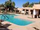 Community pool with blue water, lounge chairs, and lush desert landscaping at 8940 W Olive Ave # 39, Peoria, AZ 85345
