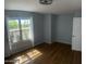 Bedroom with blue walls and wood floors with a window providing natural light at 10910 N 72Nd Dr, Peoria, AZ 85345