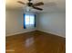 Bedroom features hardwood floors, a fan, light gray walls, and a window with natural light at 10910 N 72Nd Dr, Peoria, AZ 85345