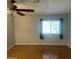 Spacious bedroom with hardwood floors, a ceiling fan and a window with natural light at 10910 N 72Nd Dr, Peoria, AZ 85345