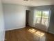 Bright bedroom with hardwood floors, a window with curtains, and light blue walls at 10910 N 72Nd Dr, Peoria, AZ 85345