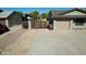 Spacious driveway leading to a well-maintained home with a garage and secure wooden gate at 10910 N 72Nd Dr, Peoria, AZ 85345