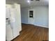 Kitchen area featuring hardwood floors, white cabinets, and modern white refrigerator at 10910 N 72Nd Dr, Peoria, AZ 85345