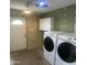 Bright laundry area features a newer Samsung washer and dryer, an exterior door, and overhead storage at 10910 N 72Nd Dr, Peoria, AZ 85345