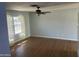 Bright living room with hardwood floors, ceiling fan and large window overlooking front yard at 10910 N 72Nd Dr, Peoria, AZ 85345