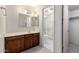 A bathroom with wood vanity, cultured marble countertop, framed mirror and walk-in shower at 11026 N 28Th Dr # 81, Phoenix, AZ 85029