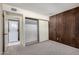 Comfortable bedroom with wood accent wall, closet with sliding doors, and adjacent laundry area at 11026 N 28Th Dr # 81, Phoenix, AZ 85029
